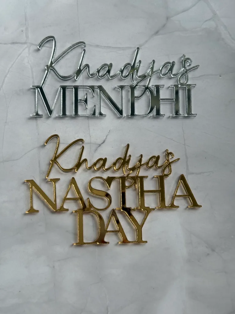 Silver and gold mirror plaques reading Khadija's Mendhi and Khadija's Nastha Day